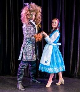 Image: Belle holds hand with the Beast on the stage at the Epsom Playhouse