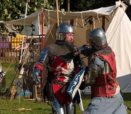Image: Two re-enactors in armour do battle