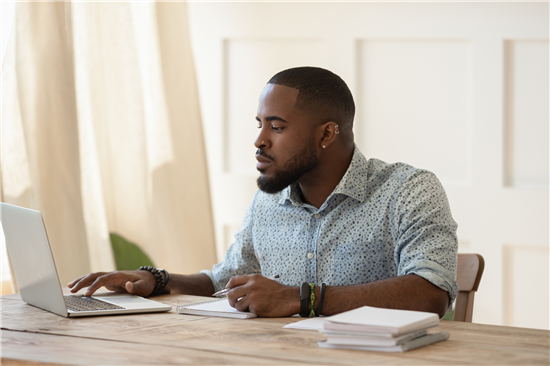 Image: man taking part in an online survey via a laptop