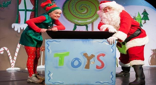 Image: santa and an elf examining a huge Christmas present 